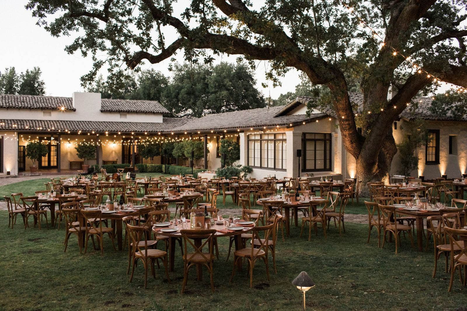 Outdoor wedding reception with string lights and tables