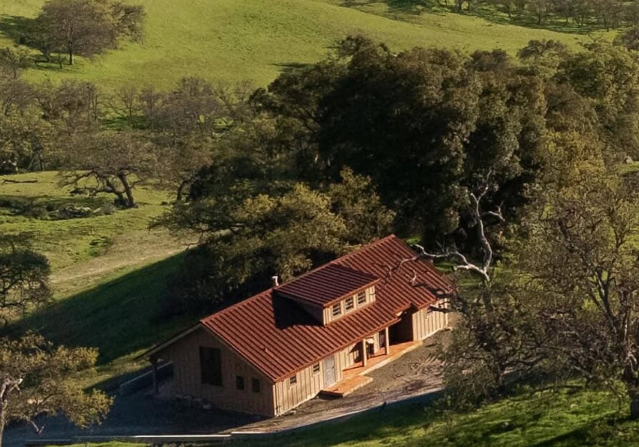 Aerial view of house in wooded area.