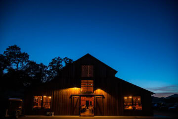 Lit barn at dusk with blue sky