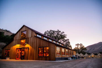 Rustic barn with tents at dusk