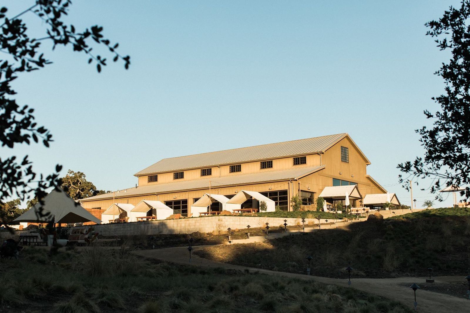 Rustic barn exterior with outdoor seating and awnings.