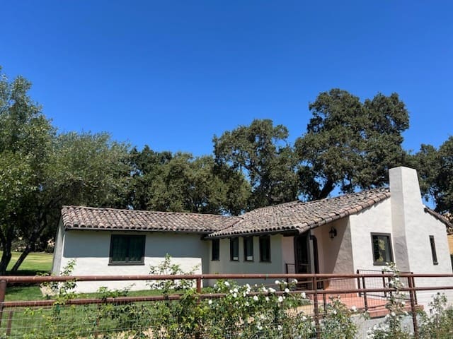 Single-story house with trees in background.