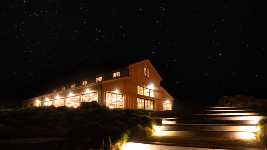 Illuminated barn under starry night sky