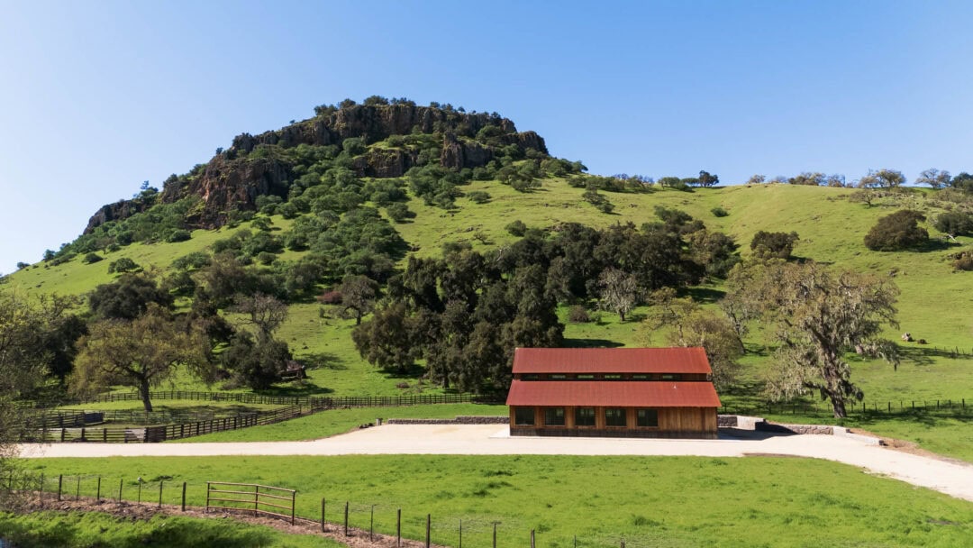 Barn with a green hill background