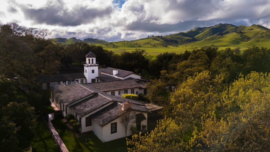 Rustic building with green hills in background