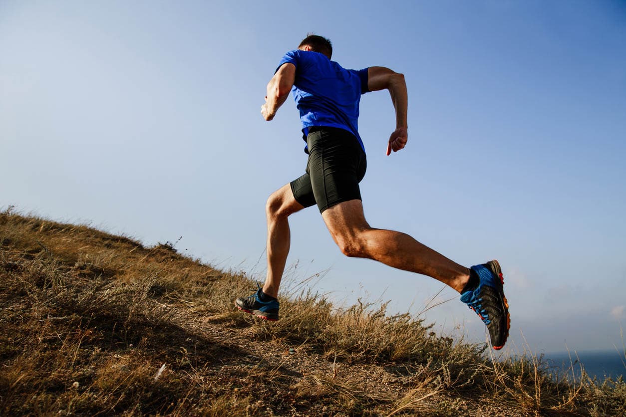 Person running uphill on a trail.