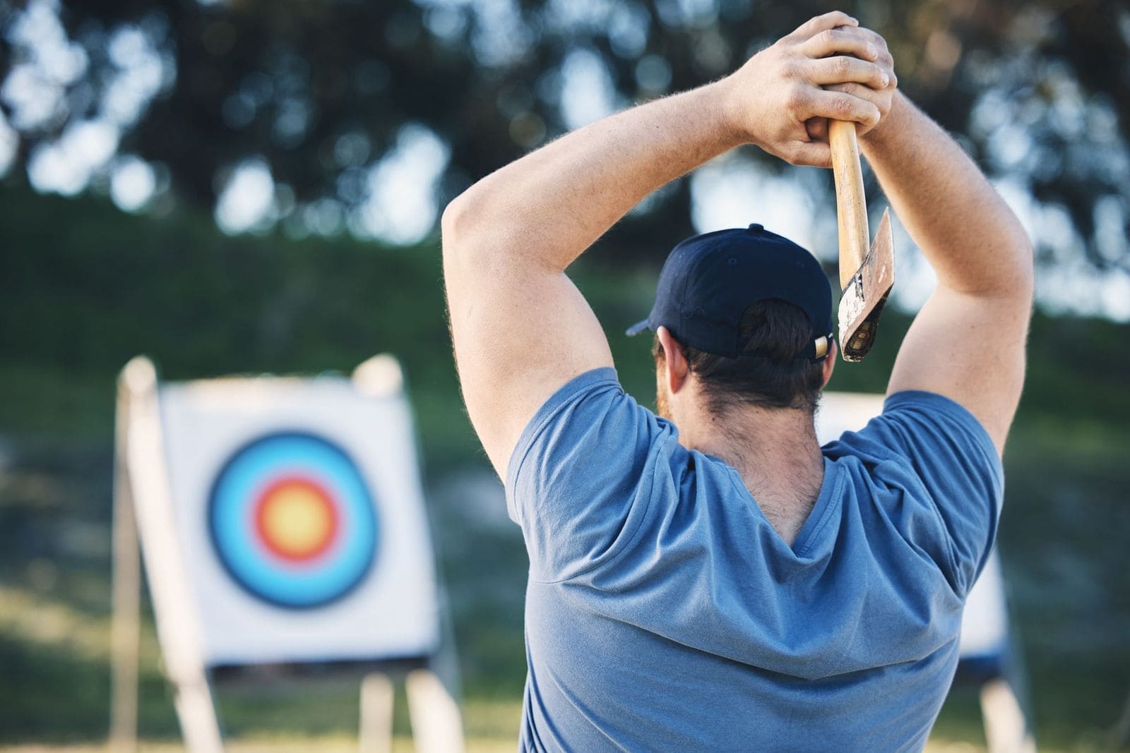 Man aiming to throw axe at target