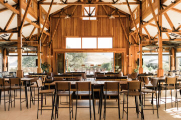 Spacious wooden event venue with large windows.